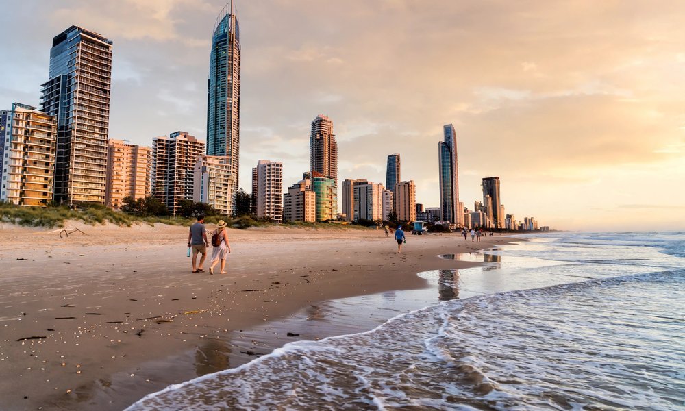 Broadbeach cafe strip on the Gold Coast at dusk with palm trees and outdoor diners