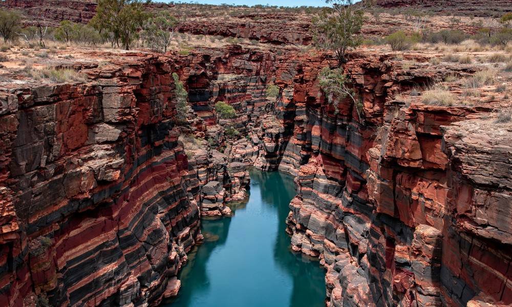 Red gorge walls and a turquoise pool in Karijini National Park