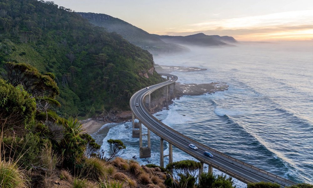 Sea Cliff Bridge curving over the ocean on the Grand Pacific Drive at sunrise