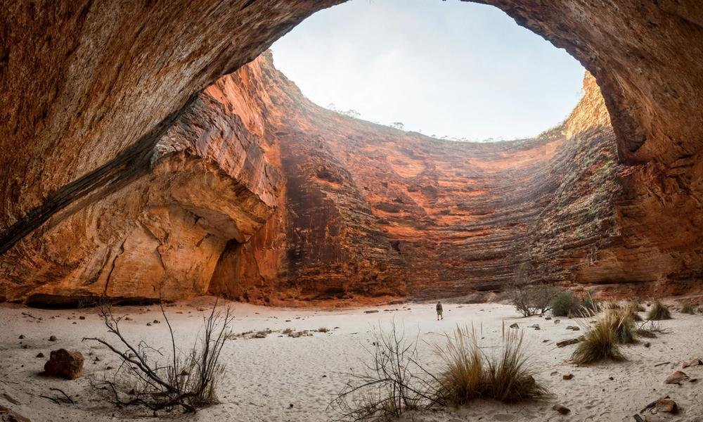 Cathedral Gorge amphitheatre with tall curved sandstone walls in Purnululu National Park.