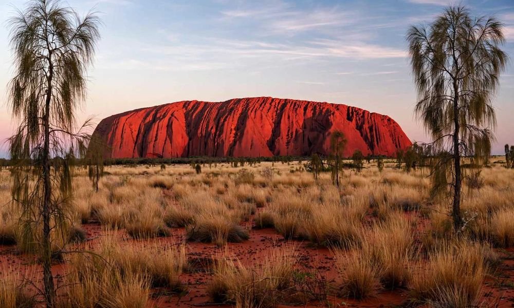 Uluru glowing red at sunrise in the Red Centre