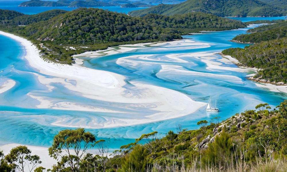 Sailing boats anchored in turquoise water among the Whitsunday Islands on a clear day